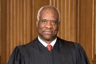 Personal Impact: Speaking at a judicial conference in Aventura, Florida, on May 14, 2026, Justice Clarence Thomas shared rare personal reflections on the state of the U.S. judiciary. Thomas described the current security environment as "very dicey," a phrase he repeated several times to underscore the risks that have limited his ability to move freely in public. He noted that these concerns have even impacted his personal life, preventing him from attending University of Nebraska athletic events as frequently as he once did. Despite the "hideous" atmosphere he described in Washington, the 77-year-old justice emphasized his commitment to the bench, focusing on the upcoming 250th anniversary of the Declaration of Independence. Photos: Collection of the Supreme Court of the United States (Portrait); Win McNamee / Getty Images (Podium)