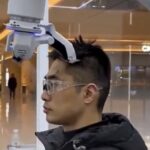 Precision Grooming: Major urban centers across China have begun commercializing fully autonomous, AI-driven robot barber kiosks to offer rapid and highly uniform haircuts. As captured in image_32.png, the system utilizes advanced 3D structural scanning technology to map out the unique contours of an individual's scalp and hair density before executing the trim with millimeter precision. Programmed with a wide variety of domestic and international styling templates, these automated booths operate around the clock. They cater heavily to budget-conscious consumers by slashing the price of a standard men's trim to an ultra-cheap 60 yen ($0.40 USD), heavily disrupting the traditional local grooming service industry. Photo: Phemex News / Xinhua