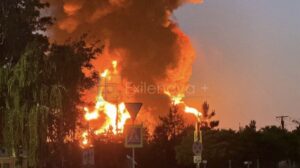 A massive fireball and thick column of dark smoke erupt into the twilight sky following a successful long-range Ukrainian drone strike on a critical Russian oil infrastructure facility. Source: Exilenova+/Telegram via The Kyiv Independent