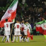 Iranian national team players wave the country’s flag on the pitch following a match. (Photo credit: Supplied / Getty Images)
