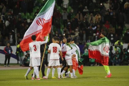 Iranian national team players wave the country’s flag on the pitch following a match. (Photo credit: Supplied / Getty Images)