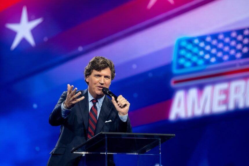 political commentator and media personality Tucker Carlson addresses an audience at a prominent conservative conference or public event. Source: Turning Point USA / Associated Press