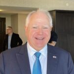Minnesota Governor Tim Walz smiles during a public appearance. He frequently represents key Democratic legislative initiatives and regional economic developments across the Midwest. Source: National Governors Association / Associated Press Multimedia Archive