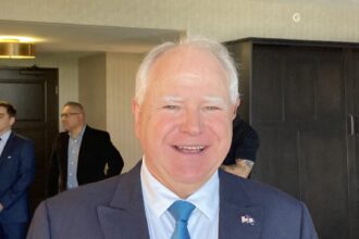 Minnesota Governor Tim Walz smiles during a public appearance. He frequently represents key Democratic legislative initiatives and regional economic developments across the Midwest. Source: National Governors Association / Associated Press Multimedia Archive