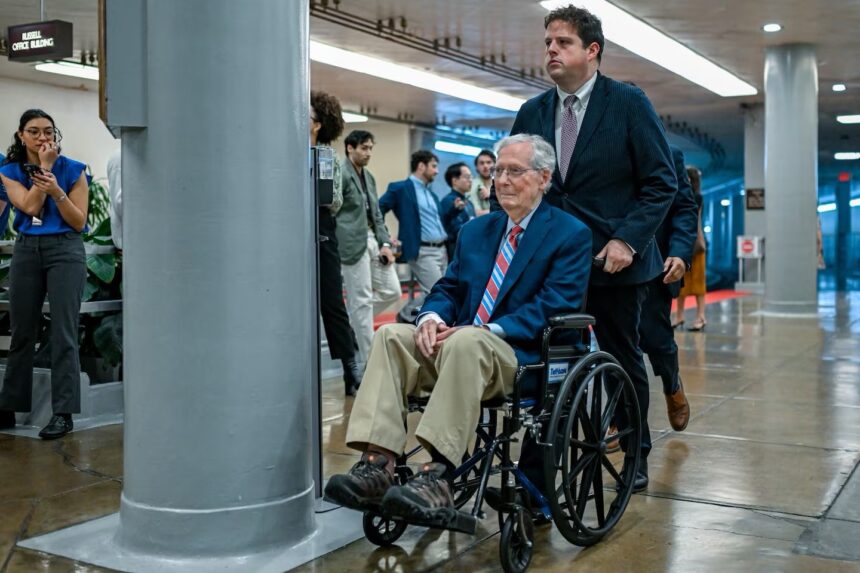 former Senate Republican Leader Mitch McConnell is assisted by an aide while using a wheelchair in the hallways of the U.S. Capitol complex. McConnell began regularly utilizing a wheelchair to navigate the Capitol following a series of health challenges and falls. Source: Getty Images North America / Congressional Pool Archive