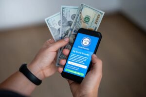 A smartphone displaying the official *my Social Security* login portal alongside U.S. dollar banknotes. **Photo:** Stock photo via Getty Images / Shutterstock
